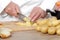 Detail of hands of chef slicing potatoes