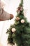 detail hands decorating christmas tree for hollidays