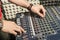 Detail of the hands of a man manipulating a mixing desk