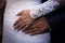 Detail with hands of newlyweds displaying wedding rings