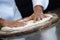 Detail of the hands of a pizza chef chef who works for the various stages of preparing a real Italian pizza homemade with yeast fl