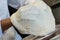 Detail of the hands of a pizza chef chef who works for the various stages of preparing a real Italian pizza homemade with yeast fl