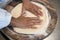 Detail of the hands of a pizza chef chef who works for the various stages of preparing a real Italian pizza homemade with yeast fl