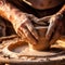 Detail of the hands of a potter shaping a piece of clay
