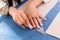 Detail of hands with scissors at tailor shop cutting cloth