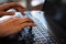 Detail of hands working on computer keyboard