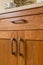 Detail of high quality wood cabinets with bronze cabinet hardware and quartz countertop in contemporary home kitchen