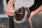 Detail of horse owner hands cleaning horse hoof with a hoof picker.