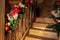 Detail house wooden staricase handrails railings decorated with artificial holly poinsettia flower, burlap bow