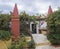 Detail from interior of the orthodox Monastery of Paleokastritsa, red pillars and door with flower pots and vine arbor with