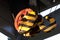 Detail of large industrial double pulley hook painted with yellow and black stripes, placed on gantry bridge portal crane.