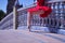 Detail of legs and feet of adult female Hispanic classical ballet dancer in red tutu doing figures leaning on a nice tiled