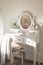 Detail of makeup dressing table with large mirror, diary and organizer. White and clean workstation in the master bedroom