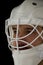 Detail of a male face in a white goalie hockey mask.