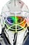 Detail of a male face in a white goalie hockey mask.Colorful light in the face.