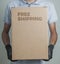 Detail of man with black gloves holding a cardboard box written free shipping to deliver products on gray background.