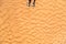 Detail of man legs with sandals on sandy dunes