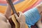 Detail of man relaxing on a hammock and playing ukulele