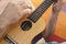 Detail of man relaxing on a hammock and playing ukulele