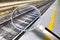Detail of a metal European railway with sidewalk and yellow safety dividing line - Concept image seen through a magnifying glass