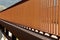 Detail of modern rusty orange colored pedestrian and bicycle bridge railing. Strong contrast of light and shadow, abstract