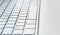 Detail of a modern white computer keyboard dirty and dusty on a white table