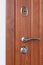 Detail of Modren style metallic door handle on wooden door.