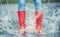 Detail of a moment when red polka dot rain boots jumped into a puddle of water, splashing all around