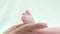 Detail of mother hands holding baby sole, delicate touch of little foot