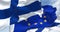 Detail of the national flag of Finland waving in the wind with blurred european union flag in the background on a clear day