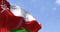 Detail of the national flag of Oman waving in the wind on a clear day