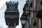 Detail of an old lamp post wih the Santa Justa lift on the background in the city of Lisbon