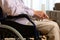 Detail of old man in wheelchair with hands on lap