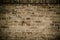 Detail of old and weathered grungy brown brick wall with desaturated colors surface texture background