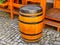 A detail of a old wooden barrel standing on road made of cobblestones