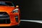 Detail of the one LED headlights orange sport car on black background