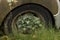 Detail of an overgrown tyre and wheel of an abandoned decay car urban exploration