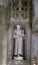 Detail in the park - old stone statue of monk with cross and baby, Quinta da Regaleira in Sintra, Portugal.