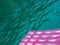 Detail of a pink inflatable pad mattress on turquoise water