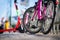 Detail of pink public sharing bicycle on the street with the red electric scooter in the background.