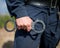 Detail of a police officer holding handcuffs.