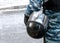 Detail of policeman wearing in camouflage holding protective helmet