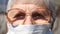 Detail portrait of granny in protective mask from virus. Elderly woman looking into camera with pensive sight. Concept