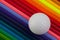 Detail of rainbow colorful pencil and golf ball on the desk