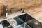 Detail of a rectangular designer kitchen sink with chrome water tap.