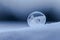 Detail rich frozen round soap bubble on snow