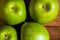 Detail on ripe green apples on wooden table