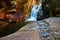 Detail of rocks and rock vein in gorge with peaceful waterfall tucked into canyon