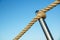 Detail of rope railing of beach walkway, old metal pole, seaside vacation, tranquility, relaxation,