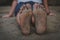 detail of the sandy feet of an adult man sitting on the beach relaxed